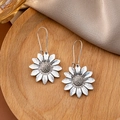 Detail view of vintage silver sunflower earrings on a wooden tray with soft shadows - Antique Silver Sunflower Long Hook