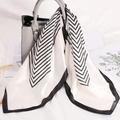 Elegante foulard in satin a righe bianche e nere annodato a una borsa a mano grigia - Bianco