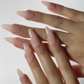 Glossy nude pink long almond shape press-on nails shown on hands with natural finish - Pointed Shape / Glossy Nude Pink