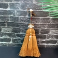 Detail of brown witch broom featuring a pink crystal, silver bee charm and colorful beads - Rose Quartz + Bee + Turtle Drop