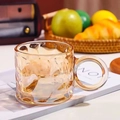 Eleganter Becher aus bernsteinfarbenem Glas mit Hammerschlagstruktur und Griff - Bernsteinfarbener Regentropfen-Becher
