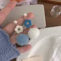 Orecchini a goccia lunga con pompon bianchi di peluche e ciondoli a fiori blu - Pendenti Pom Pom Fiore Blu Bianco