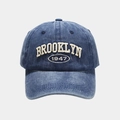 Macro view of BROOKLYN 1947 3D embroidery on washed vintage blue baseball cap - Adjustable / Navy Blue