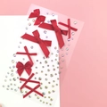 Macro shot of dark red ribbon bows and iridescent rhinestones for DIY face or nail art - BJA-638 (Red Bow Tie)