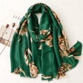 Close-up of green cotton-linen scarf with gold foil leaf patterns and fringed edges - Green