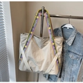 Dettaglio della borsa tote in tela beige con tracolle a fantasia e logo ricamato SJCHAO - Bianco Sporco