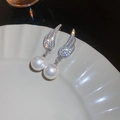 Gros plan de boucles d'oreilles ailes argentées avec cristaux et perles sur céramique - Style de Perle d'Aile Argentée (40#)