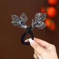 Bigoudi élégant avec des feuilles en strass brillants sur un élastique à cheveux noir - Feuilles Grises