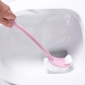 Pink long handle toilet brush with curved head cleaning the inner rim of a white toilet - Nordic Pink