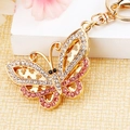 Golden butterfly keychain with white and pink crystals on a soft beige background - Small Pink Rhinestone Butterfly