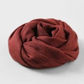 Solid deep red cotton linen blend scarf rolled into a floral shape on grey background - Light Jujube Red