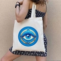 Canvas tote bag with blue graffiti Greek Evil Eye print carried by a female model - STD1804-W Sky Blue Geometric Eye