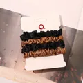 Detail of 4-pack satin scrunchies in black and coffee colors on white card - Black + Gold