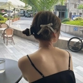 Elegant white bow hair tie shown on a bun hairstyle with jewelry and outdoor backdrop - Small Hair Clip / Gray