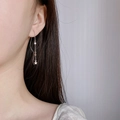 Elegant silver star tassel earrings with long chain pendant for women on model - Star Tassel Ear Threader / Silver