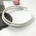 Close-up of three white glitter headbands with protective caps on a white surface - White