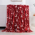 Soft red flannel Christmas blanket with white reindeer and snowflake patterns on sofa - MT02-08 (Bright Red Reindeer)