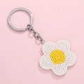 Porte-clés bohème avec fleur de marguerite perlée blanche et jaune sur fond rose pastel - Fleur Blanche