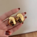 Minimalistische goldene Ohrringe in Kieselform mit hochglanzpolierter Spiegeloberfläche - Gold