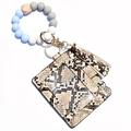 Macro detail of snakeskin pattern PU leather card holder with tassel and silicone beads - Brown Snakeskin