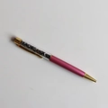 Macro detail of luxury ballpoint pen with black crystal stones and rose red metal barrel - Terahertz / 14cm Black Ink Refill
