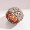 Dettaglio di un bracciale punk largo in pelle con borchie e gemme sfaccettate - Bianco