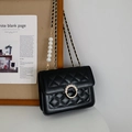 Detail of black quilted crossbody bag with gold chain and white pearl shoulder strap - Small / Black