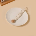 Détail de l'attache-tétine en coton fleuri avec pince en bois de hêtre sur une assiette en céramique - Style Floral Beige (18)