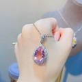 Detail of a 7.5ct pear-cut pink morganite pendant necklace held by a hand - Pink Zirconia Pendant (No Chain)