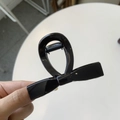 Detailed macro shot of the glossy black bow-shaped hair claw clip with reflective finish - Medium 8cm / Glossy Black