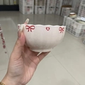 White ceramic bowl with wavy rim featuring red bow and heart patterns, held by hand - 4.5 Inch Lotus Bowl - Red Bow - 1pc