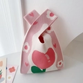 Close-up of pink knit tote bag with heart and flower patterns on a clean surface - Pink Tulip