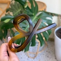 Detail showing hand-held tortoise shell hair claw clip with twisted acetate texture - Matte Light Tortoise