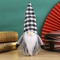 Détail d'un gnome de Noël avec chapeau à carreaux noir et blanc et barbe blanche douce - Style à Carreaux Gris