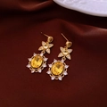 Macro view of gold-plated star horse earring with yellow oval gemstone on red silk - 34# Gold Yellow Gemstone Earrings