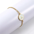 Golden Figaro chain bracelet with shell letter X pendant on white pedestal - Letter X / Gold/White Shell