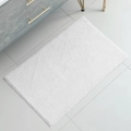 Absorbent white chenille bathroom mat with soft textured surface on tile floor - Bleached White