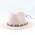Close-up of woven panama hat with shell ornaments and blue cord for a beach vacation look - Pink