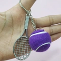 Macro view of silver tennis racket and purple felt ball keychain held by hand - 3.8cm Ball / Purple