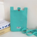Detail of mint green knit phone bag with Stannum label and silver metal clasp closure - Cyan
