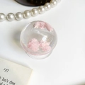 Detail einer transparenten Handy-Halterung mit weicher, rosa wolkenartiger Füllung - Rosa