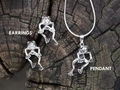 Detailed set of silver frog earrings and pendant on a rustic wood surface texture - Silver Necklace Earring Set