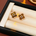 Primer plano de pendientes de trébol con ojo de tigre y perlas sobre un soporte beige - Aguja de plata Oro Marrón Estilo Flor de Trébol (WE4985)