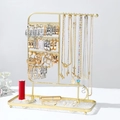 Macro view of gold metal jewelry stand with necklace hooks and earring storage tray - Multi-use Rectangular Base Style