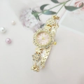 Detailed side view of golden flower watch with rhinestones and soft pink dial - Gold Case Pink