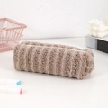 Detail of plush khaki pencil case with striped texture and durable zipper closure - Brown