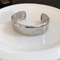 Detailopname van de zilveren ovale manchetarmband met vintage abstracte reliëfpatronen - Zilver