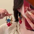 Close-up of bohemian hoop earrings with blue flowers, red stones, and shell charms - Gold-Coffee-Red Ethnic Style (23# Silver Earring Post)