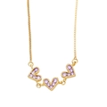 Detail of three purple crystal heart pendants on a delicate gold box chain necklace - Purple