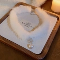 Détail du ras-du-cou en peluche blanche avec pendentif flocon argenté et perle - Style Fourrure Blanche Flocon de Neige Perle